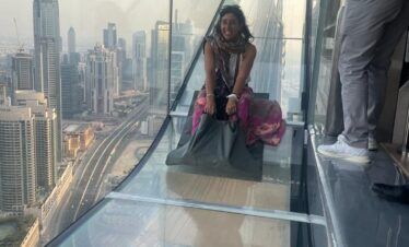 Turista disfrutando del Sky Views Slide en Dubái con vistas panorámicas a la ciudad