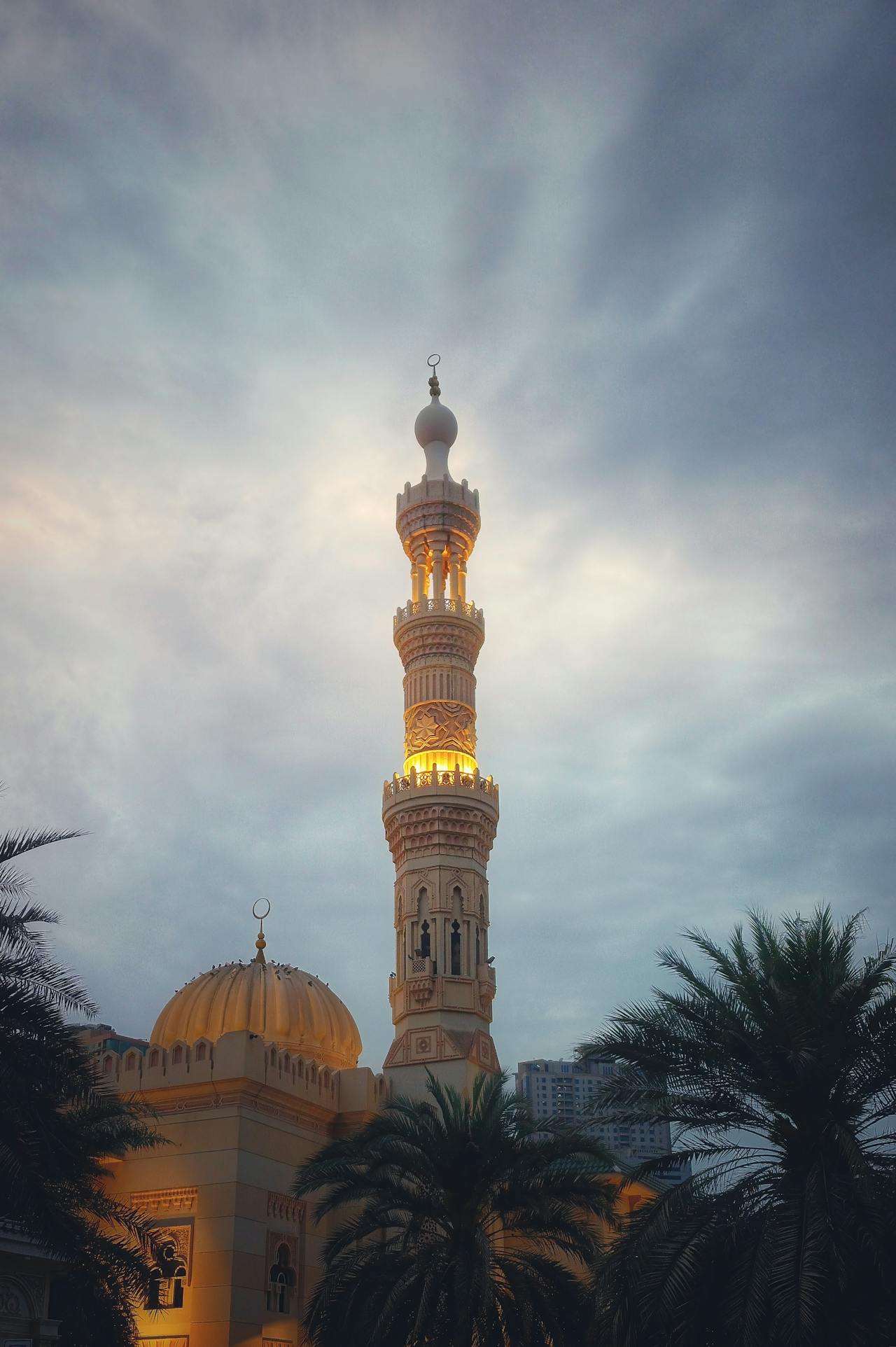 Mezquita en Sharjah iluminada al atardecer durante el tour cultural desde Dubái con Passion Dubai Tours